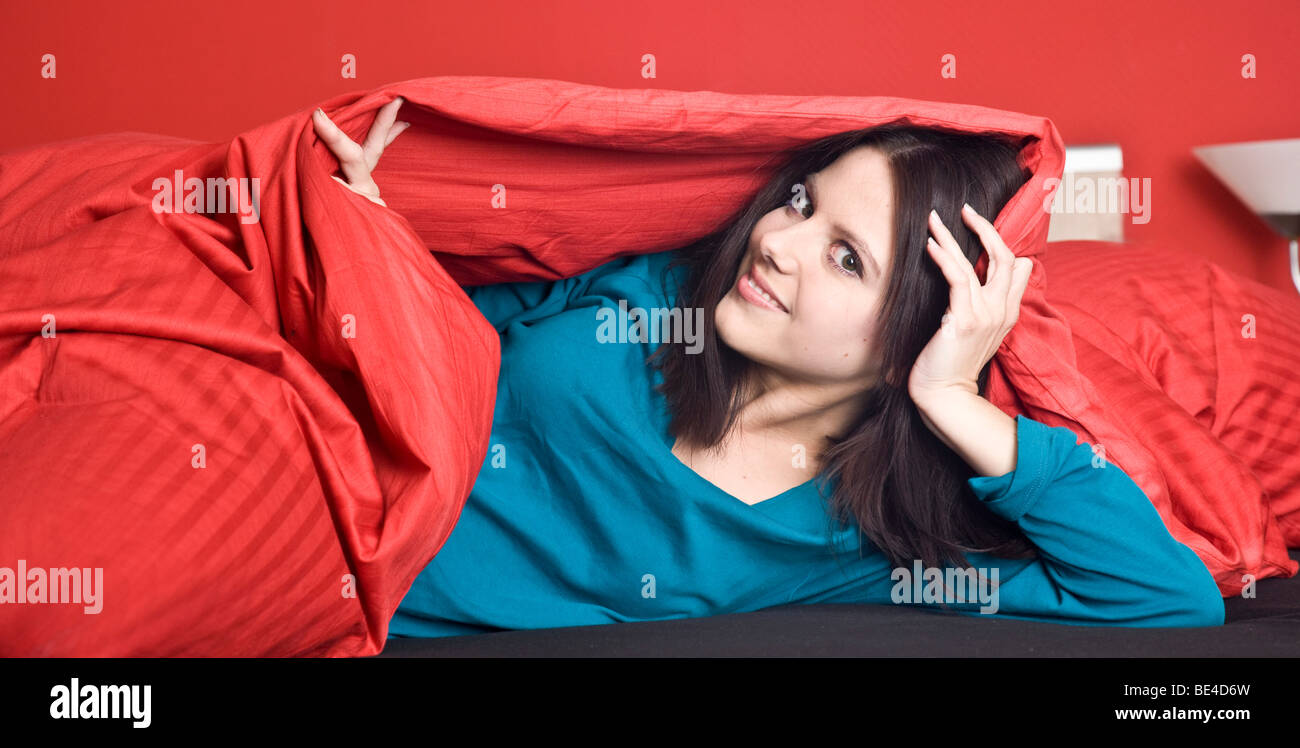 Giovane donna sotto coperta di rosso Foto Stock