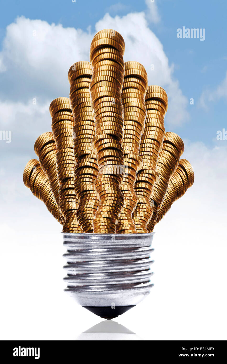 Pile di denaro nel montaggio di un bulbo di luce davanti a un cielo blu, simbolico per alti costi di elettricità Foto Stock