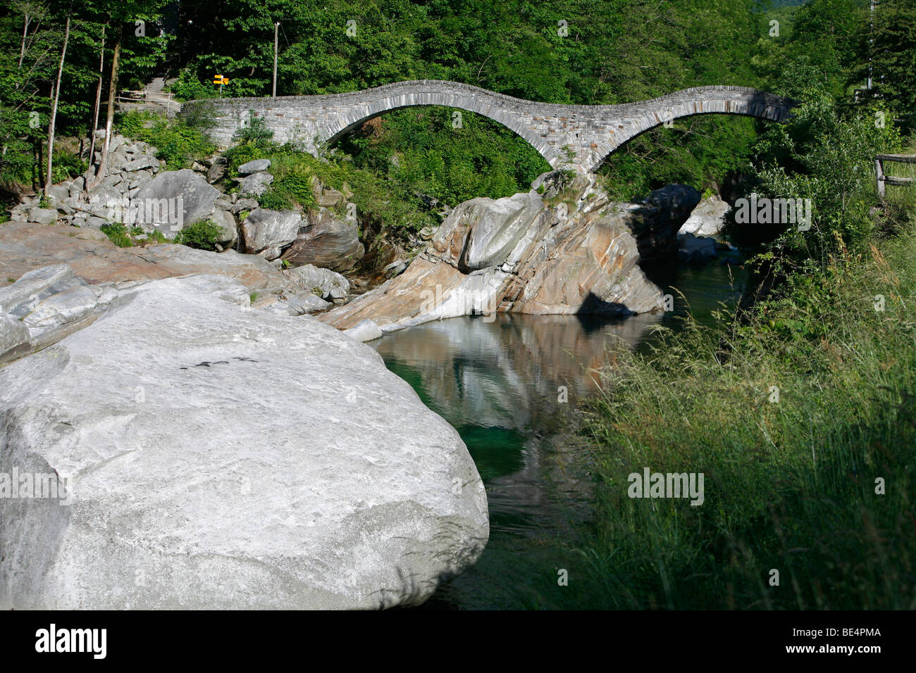 Arco in pietra Ponte dei salti e la calma che scorre il fiume Verzasca nei pressi di Lavertezzo, Valle Verzasca, Ticino, Svizzera Foto Stock