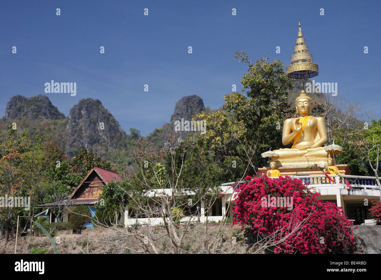 Statua dorata di Buddha di fronte montagne, si Lanna Parco Nazionale, Thailandia del Nord della Thailandia, Asia Foto Stock