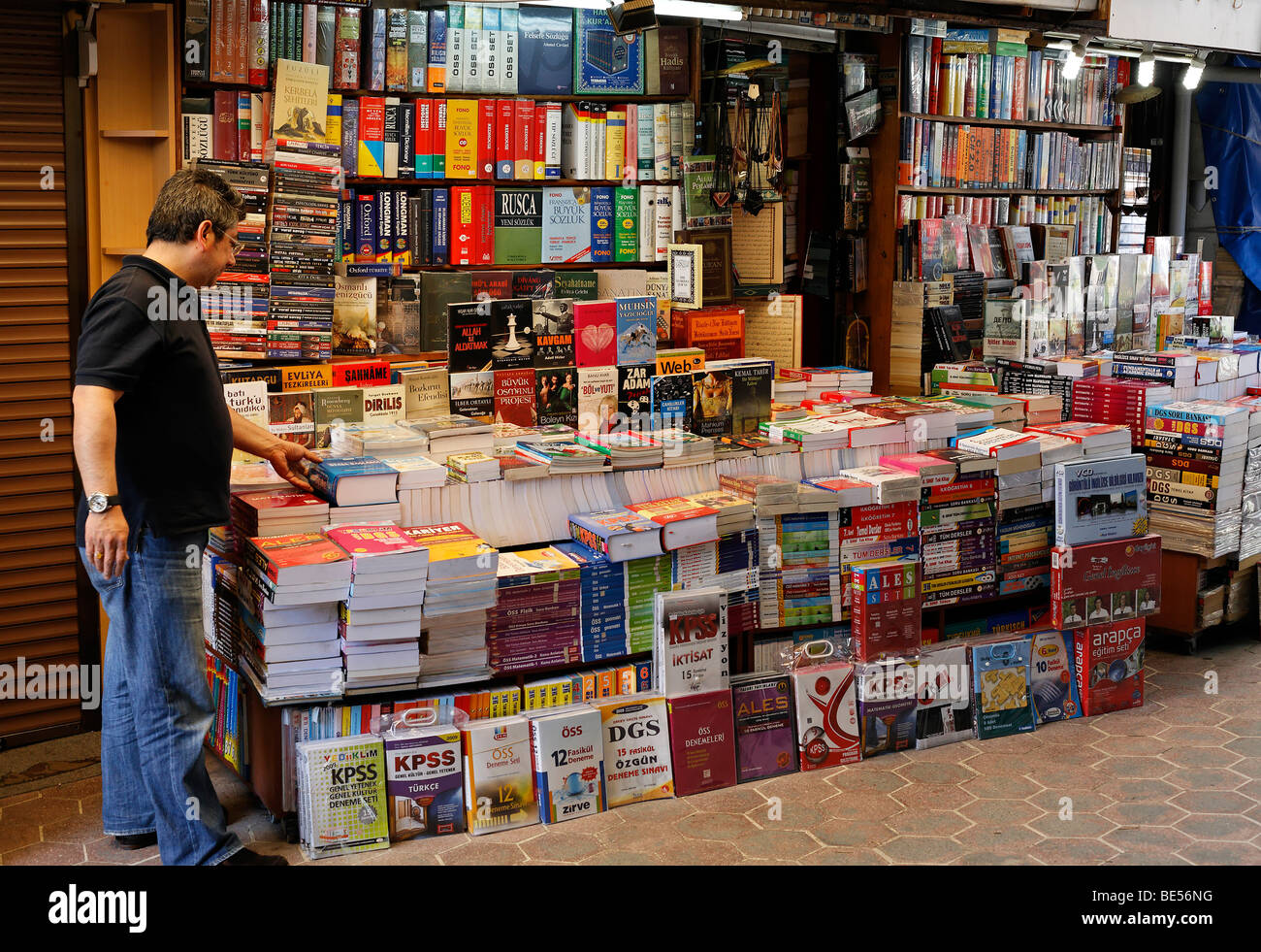 Stallo a un libro bazaar, uomo recupero per prenotare, Beyazit Square, Istanbul, Turchia Foto Stock