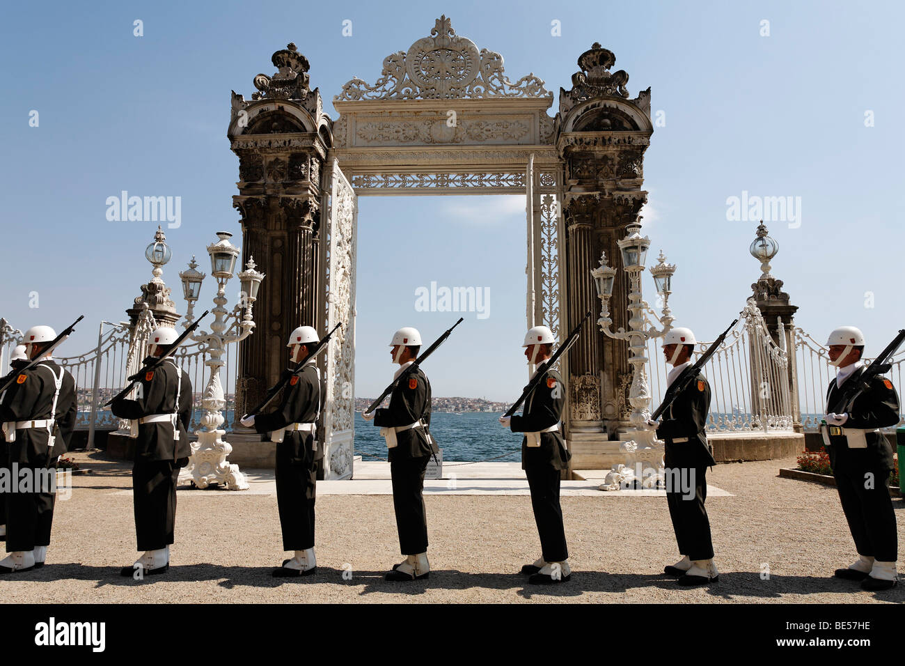 Montagna di guardia di fronte al cancello principale sul Bosforo a riva, Palazzo Dolmabahce, Besiktas, Istanbul, Turchia Foto Stock