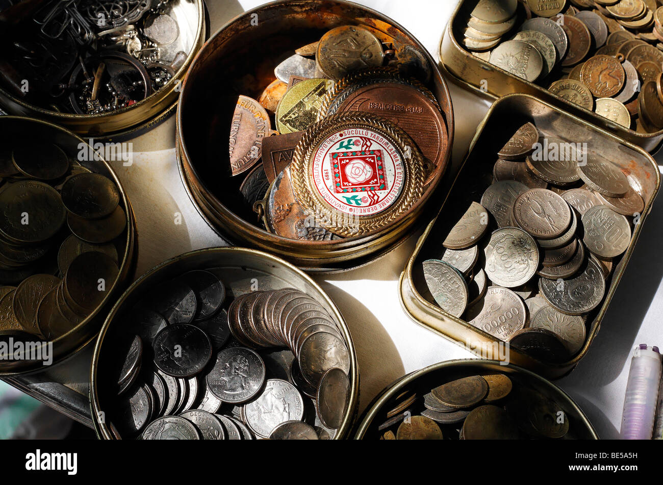 Lattine di lattina con le vecchie monete turco e distintivi di un torneo di calcio, la tabella di un venditore ambulante, grande bazaar, Beyazit Square, Ista Foto Stock