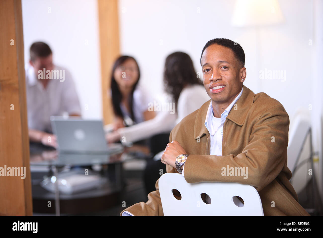 Ritratto di African American uomo in primo piano con i collaboratori in background Foto Stock