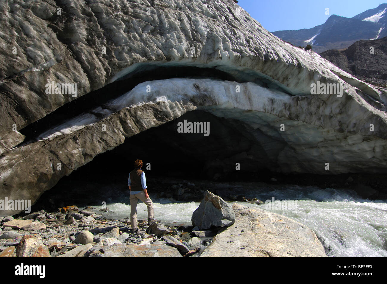 Visitatore guarda la bocca del ghiacciaio del ghiacciaio Langgletscher, Loetschental, Vallese, Svizzera Foto Stock