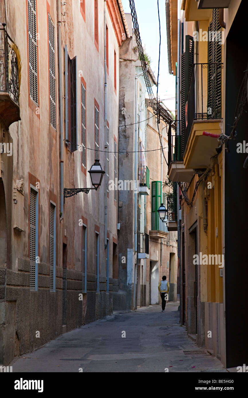 Donna che cammina attraverso la stradina nel quartiere vecchio Palma Mallorca Spagna Spain Foto Stock