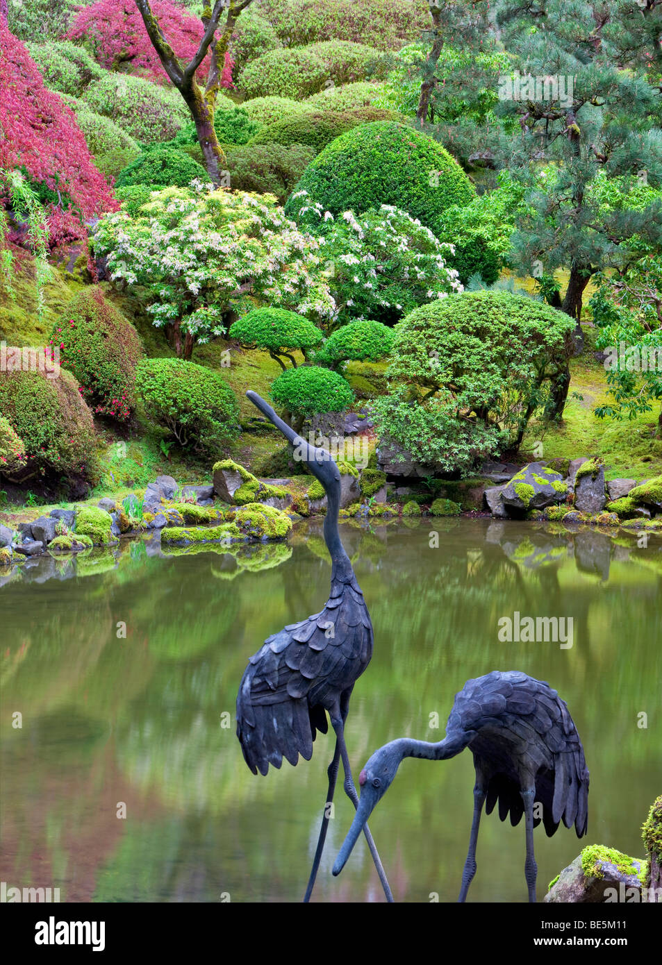 Stagno con heron scultura e inizio della primavera di crescita. Portland Giardini Giapponesi, Oregon. Foto Stock