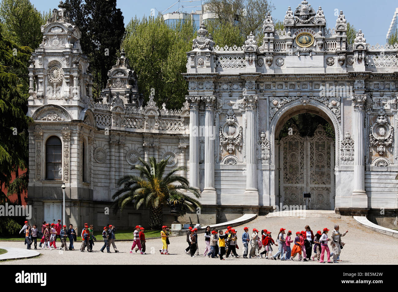 Un gruppo di bambini della scuola di passato a piedi il Sultan's Gate, il palazzo Dolmabahce e Palazzo del sultano dal xix secolo, Besiktas Foto Stock