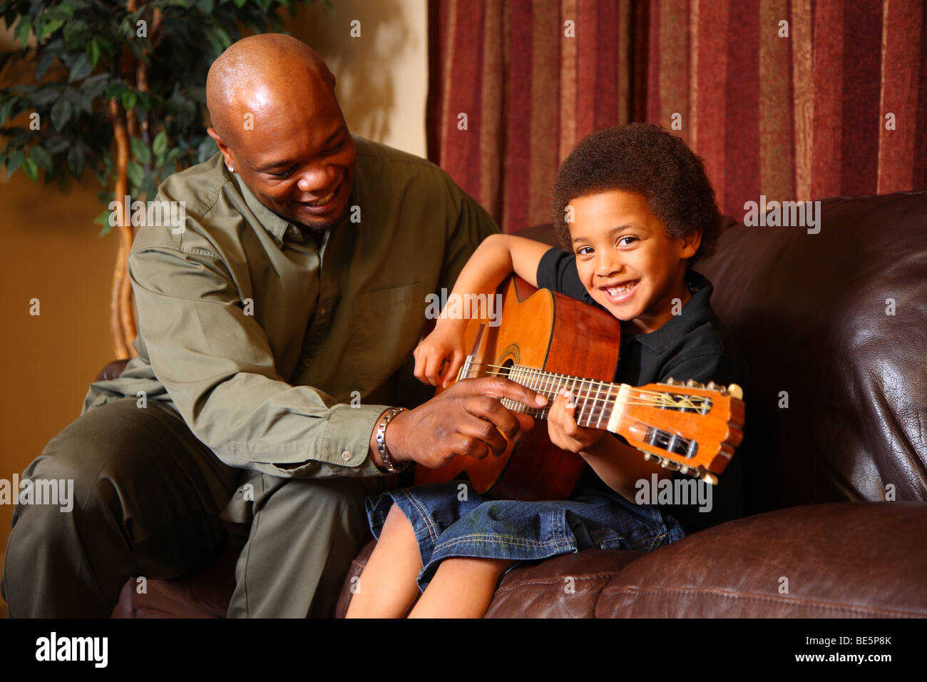 Padre figlio di insegnare a suonare la chitarra Foto Stock