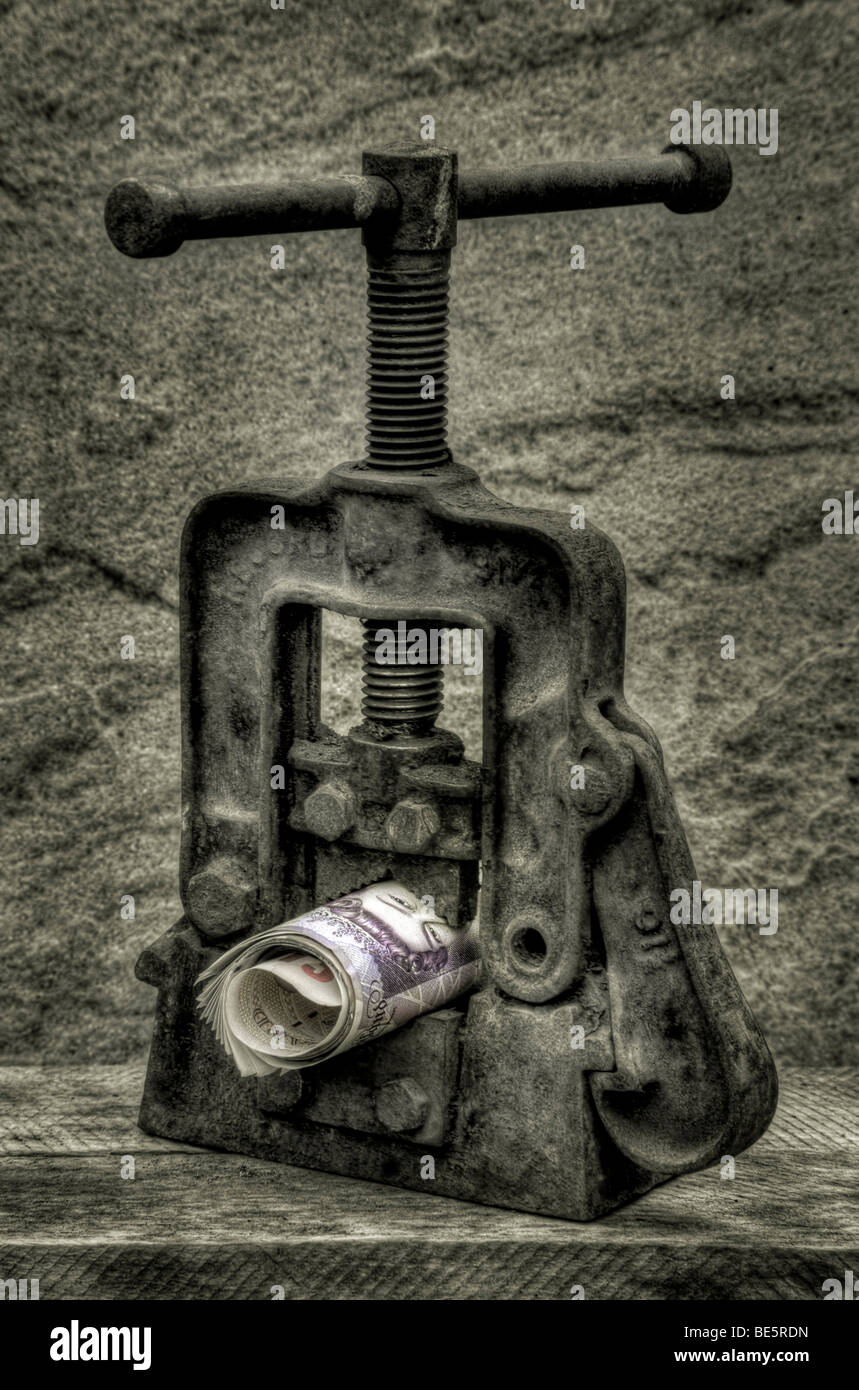Rotolo di contanti (sterline) in una morsa, raffigurante la limitata offerta di moneta, tagli di spesa,misure di austerità il credit crunch Foto Stock
