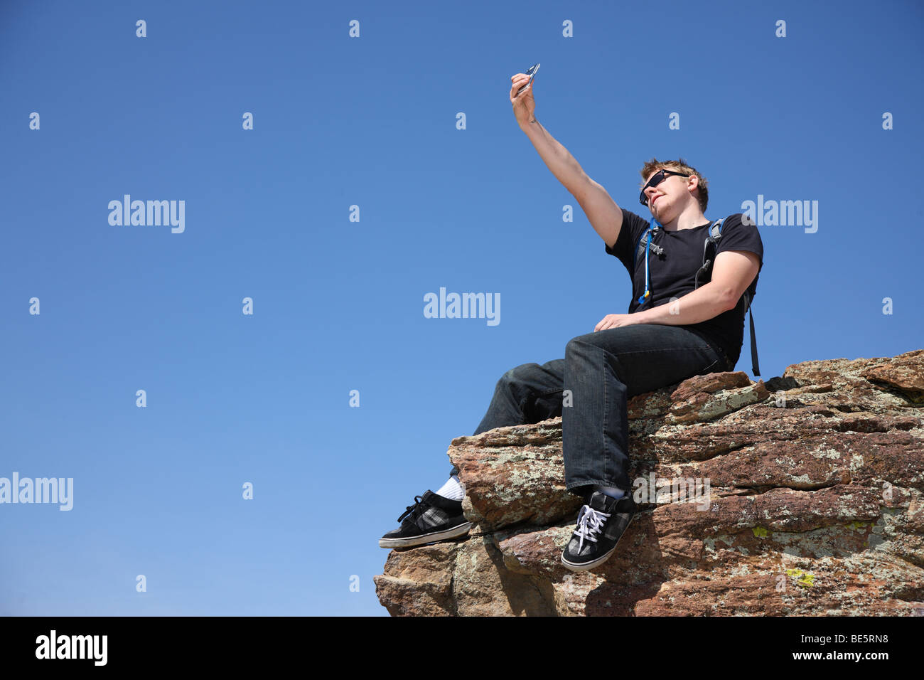 Giovane uomo prendendo autoritratto sulla cima della scogliera Foto Stock
