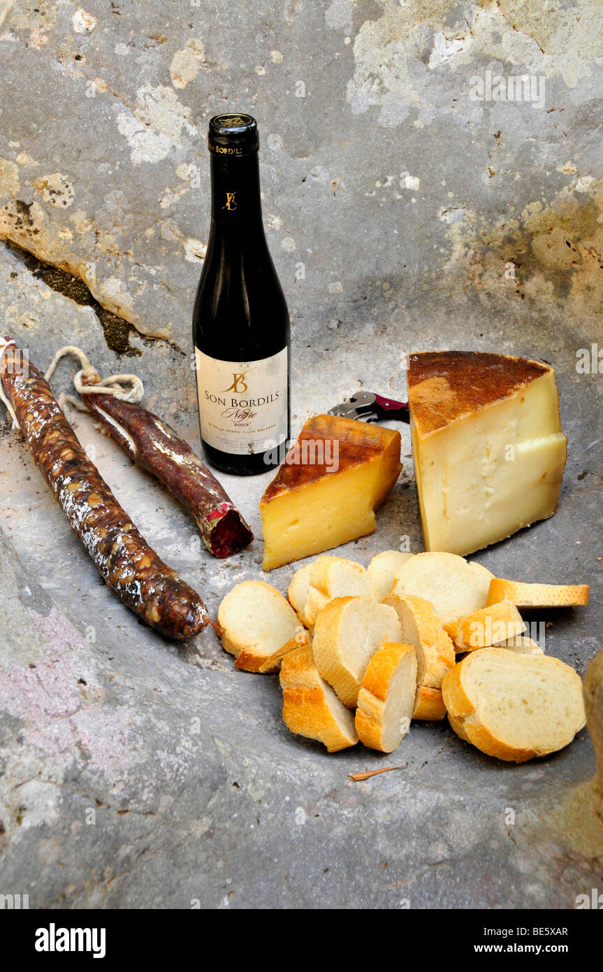 Vino, formaggio e salame su una roccia, vicino a Sóller, Maiorca, isole Baleari, Spagna, Europa Foto Stock