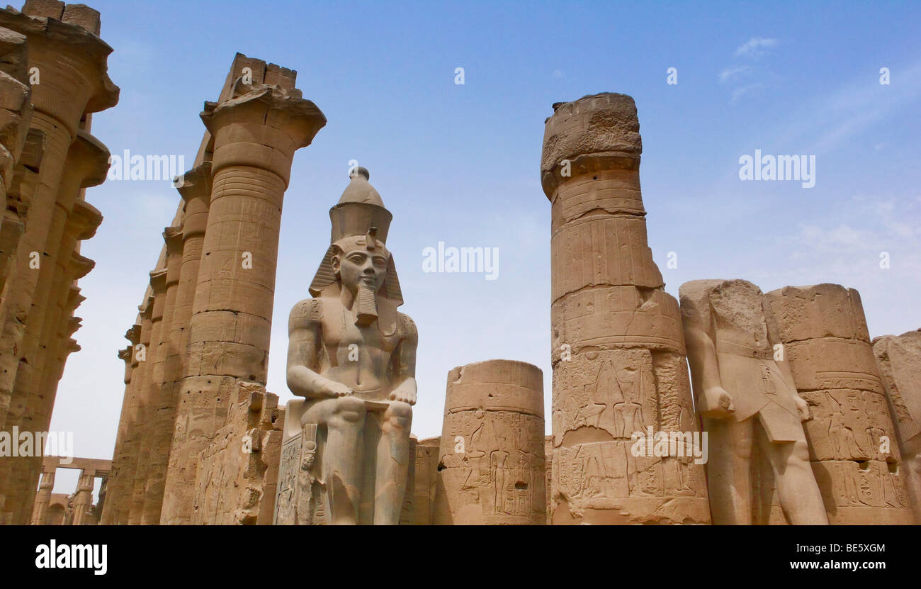 Tempio di Luxor complessa, statua di Ramses II nel primo cortile tra due massicce colonne, Tempio di Luxor, Egitto, Africa Foto Stock