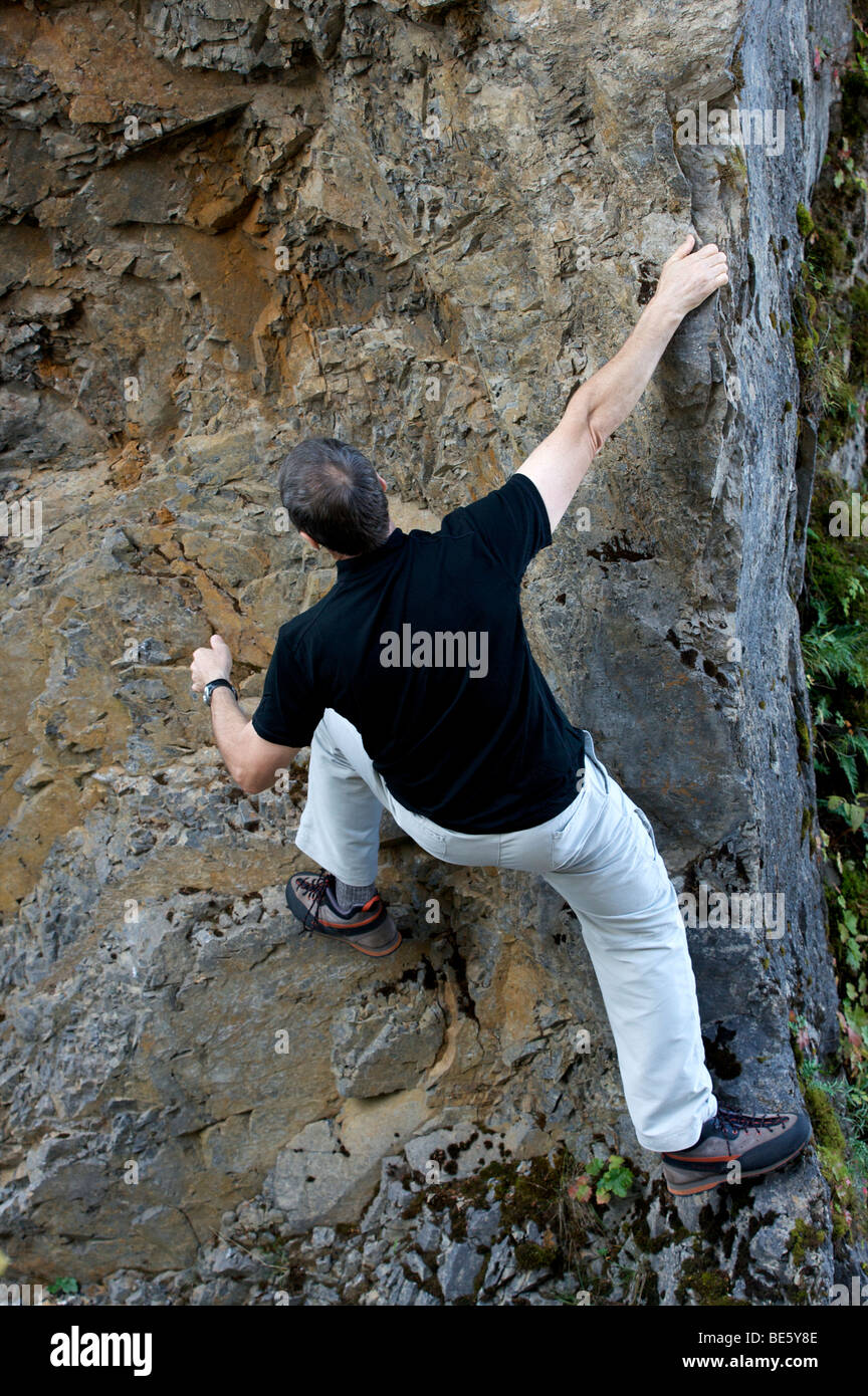 Attiva una baby boomer arrampicata su roccia senza protezione di ingranaggio Foto Stock
