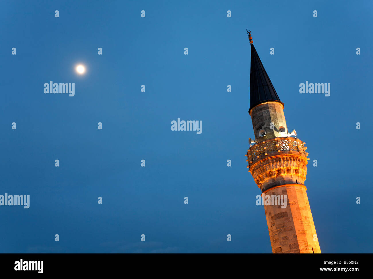 Minareto illuminato di fronte il cielo con la luna, Firuz Aga moschea, Piazza Sultanahmet, Istanbul, Turchia Foto Stock