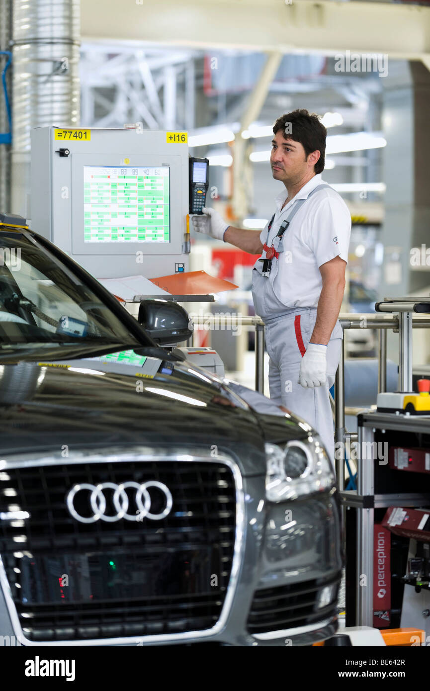 Un Audi dipendente che lavora sulla sospensione di set-up di un'Audi A6 Avant S-Line al centro di controllo dell'impianto di Audi in Neckars Foto Stock