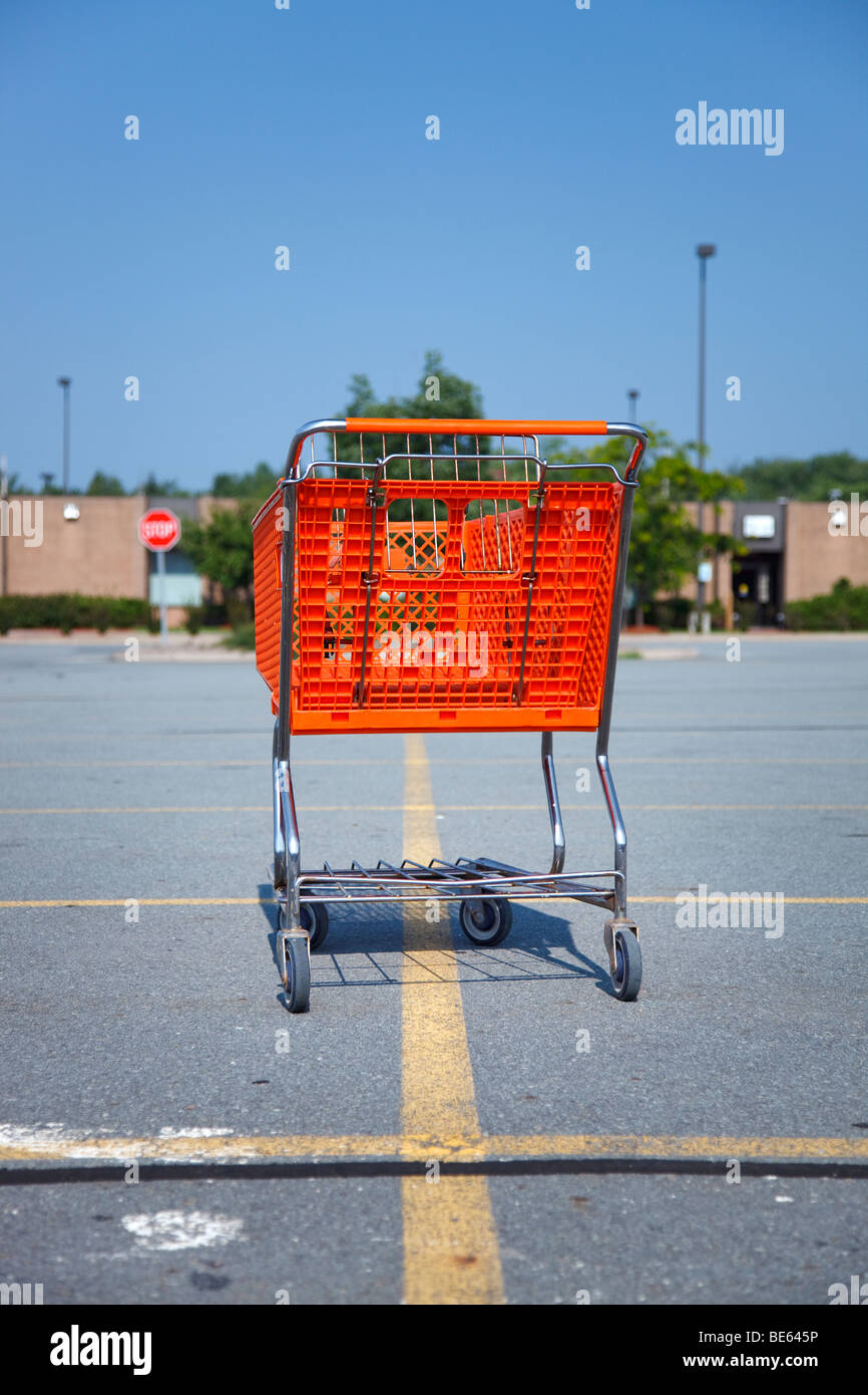 Colpo verticale di un arancio Carrello isolato su un parcheggio al centro commerciale Foto Stock