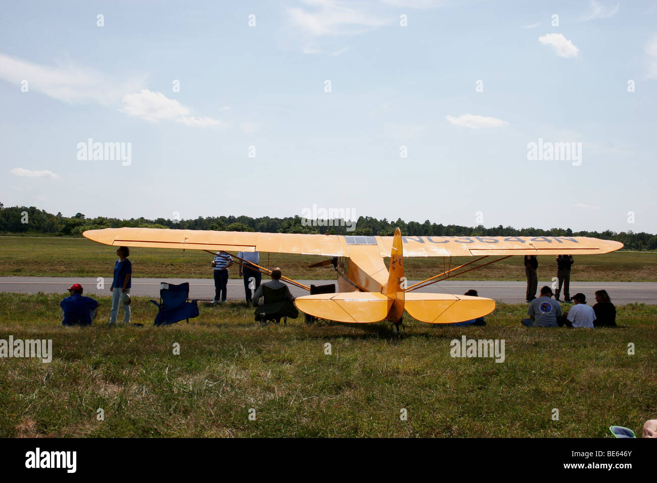 Guardare la gente air show all'ombra di le ali di un aeroplano Foto Stock