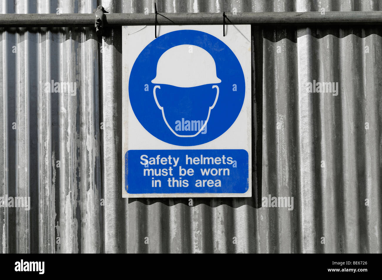Segno su un sito in costruzione che avverte che gli elmetti devono essere indossato sul sito. Foto Stock