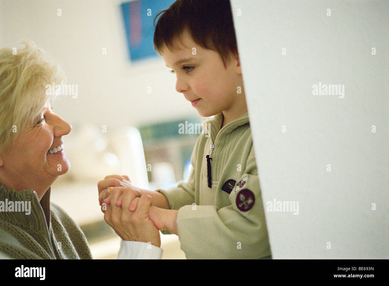 Little Boy faccia a faccia con la nonna, tenendo le mani Foto Stock
