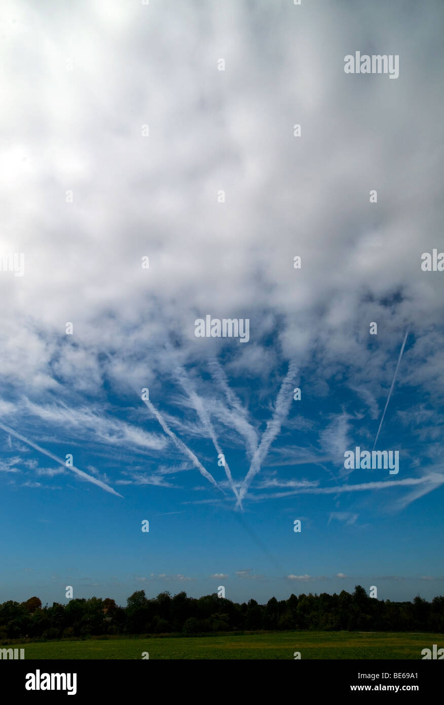 Nuvole, aeromobili scie di condensazione e un tempo parte anteriore sopra Cambridgeshire, Gran Bretagna. Foto Stock