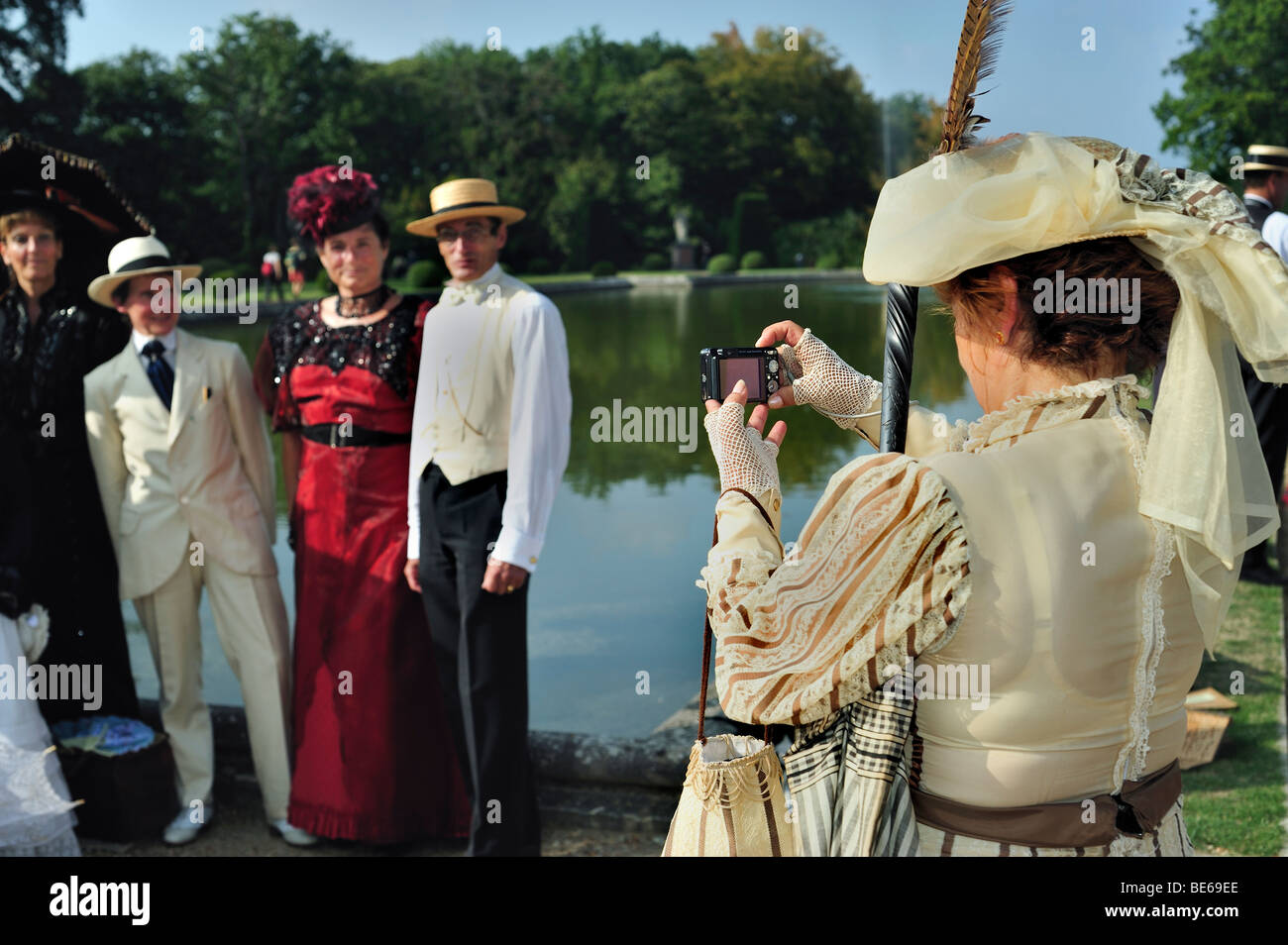 Parigi, Francia - gruppo di persone in posa, francese, Chateau de Breteuil, donna in costume, retro, dietro la spalla fotografa che scatta foto vintage Foto Stock