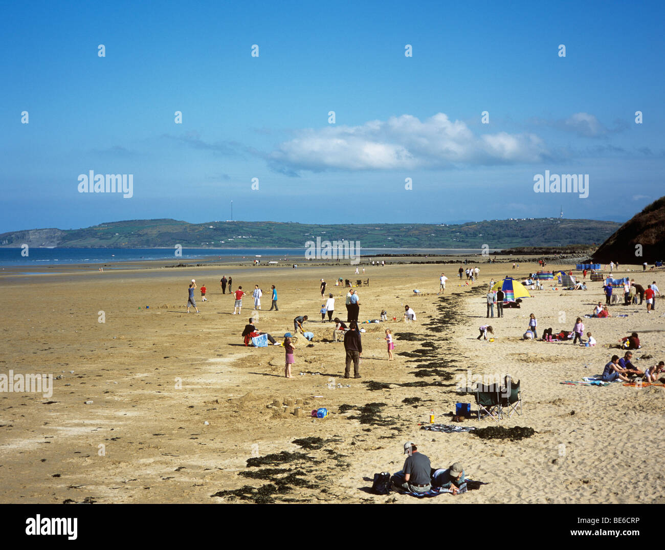 Spiaggia di sabbia con la gente sulla spiaggia Bandiera Blu a bassa marea all'inizio dell'estate. Benllech, Isola di Anglesey, Galles del Nord, Regno Unito, Gran Bretagna Foto Stock