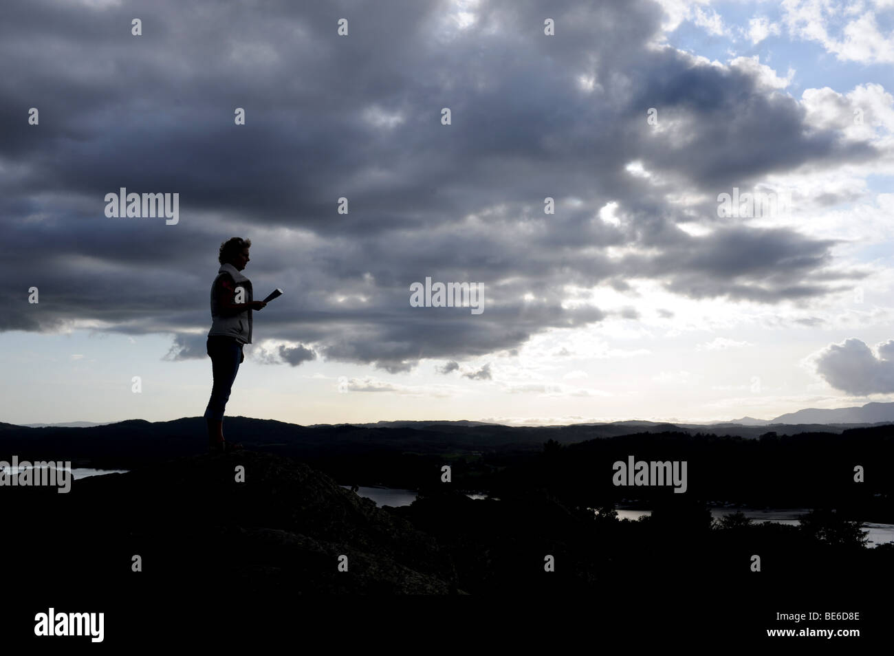 La donna sta al top della Brantfell sopra il Lago Windemere e la città di Bowness nel Lake District in Cumbria Regno Unito Foto Stock