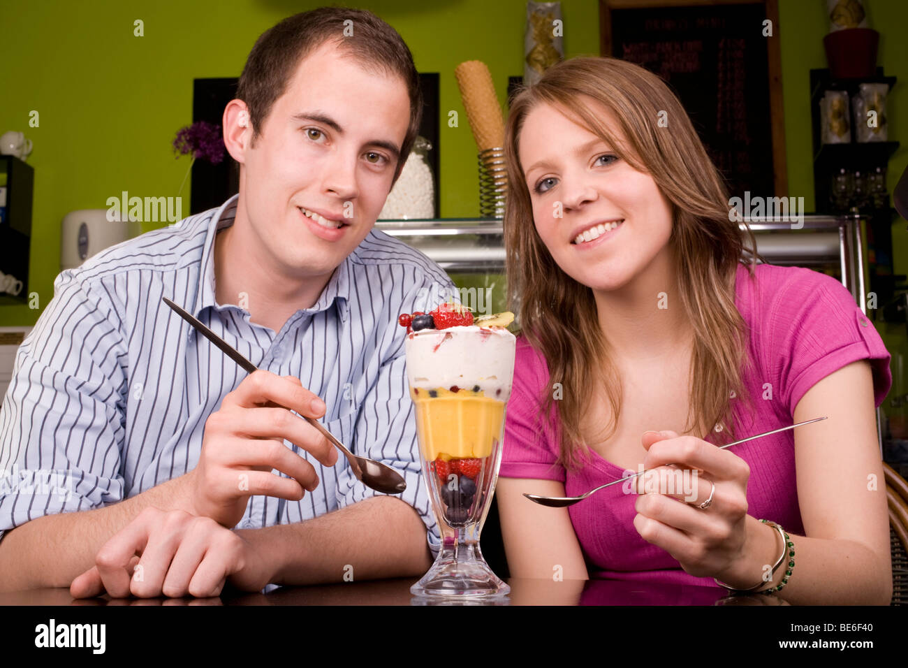 I giovani alla moda giovane godendo un kniccurbockerglory (un frutto tropicale gelato) in un luogo fresco cafe. Foto Stock