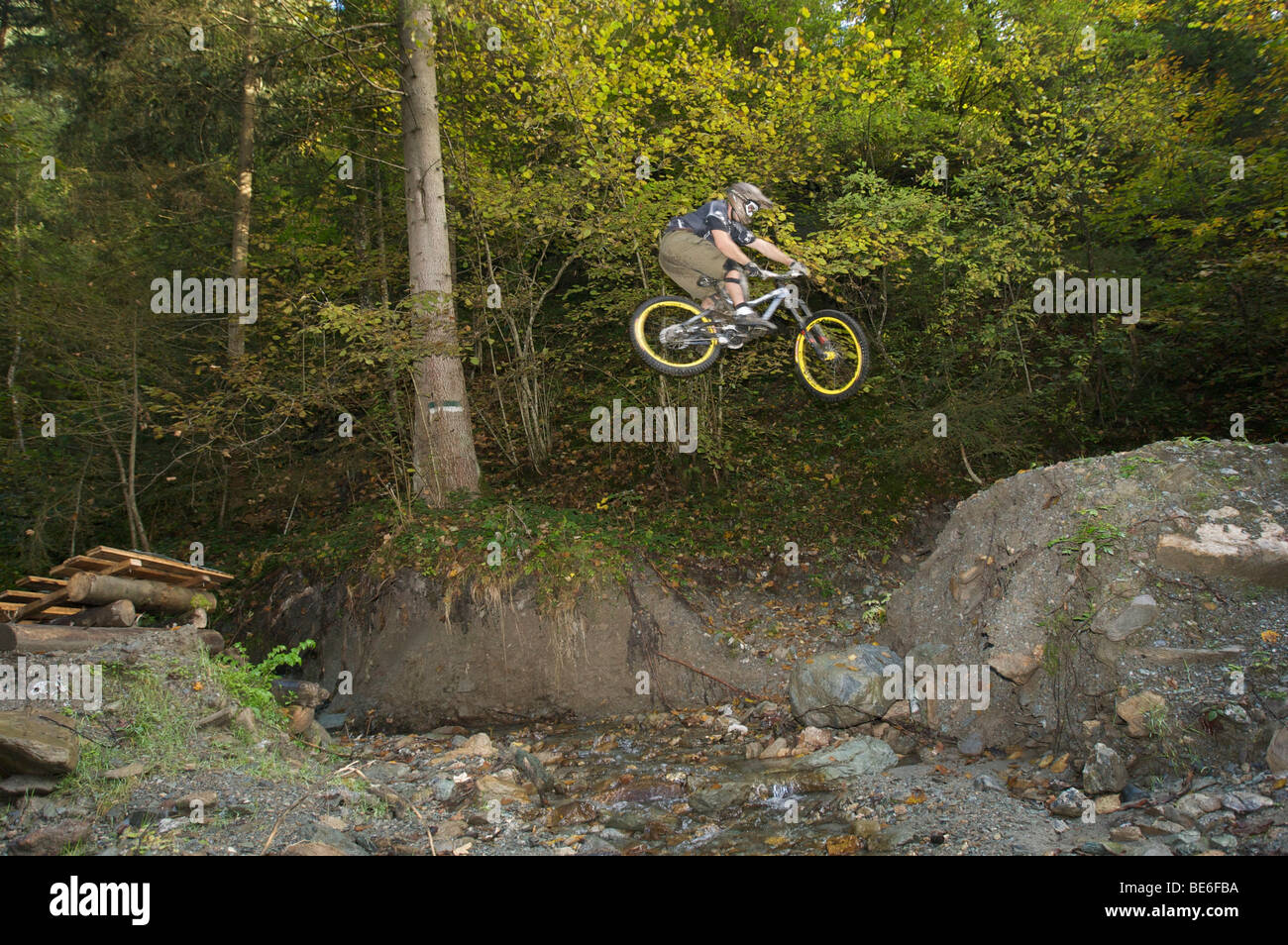 Mountainbiker saltando su un torrente su una pista downhill a Hopfgarten nella valle Brixental Tirolo, Austria, Europa Foto Stock