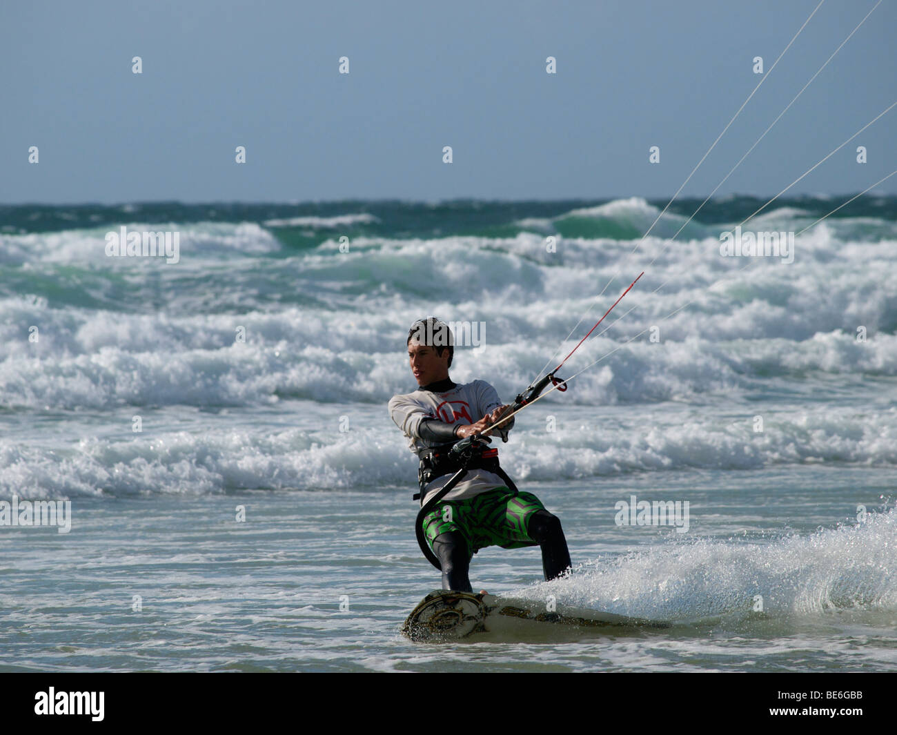 Kitesurfer accelerando attraverso le onde a Les Pieux, Normandia, Francia Foto Stock