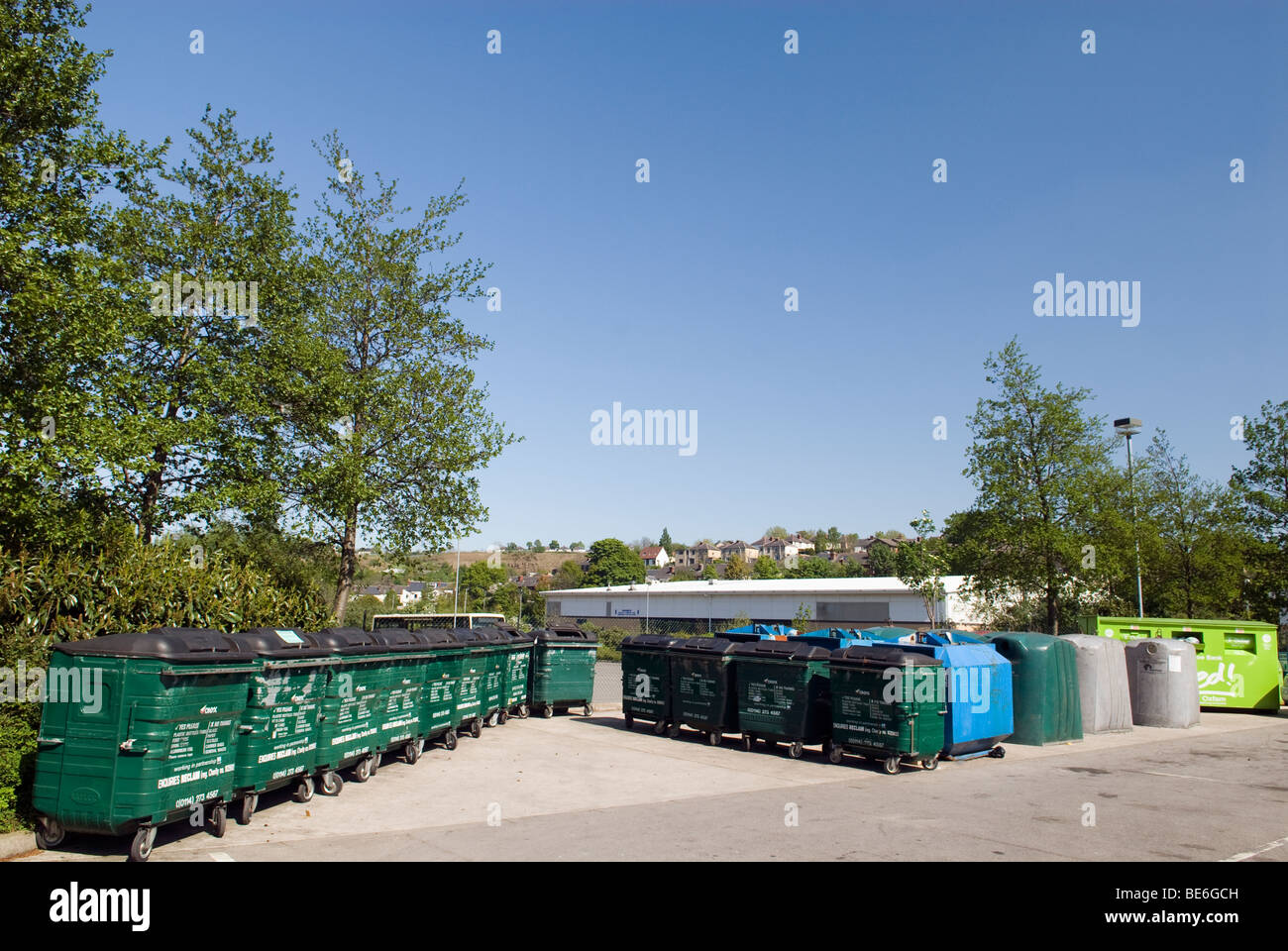 Righe di colore verde con ruote cassonetti per il riciclaggio Foto Stock
