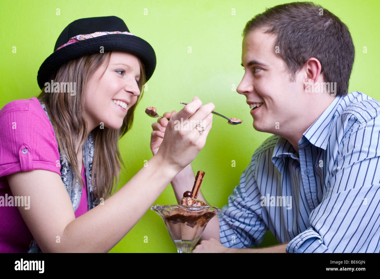 Giovane uomo e donna per alimentare ogni altro alcuni di gelato al cioccolato. Foto Stock