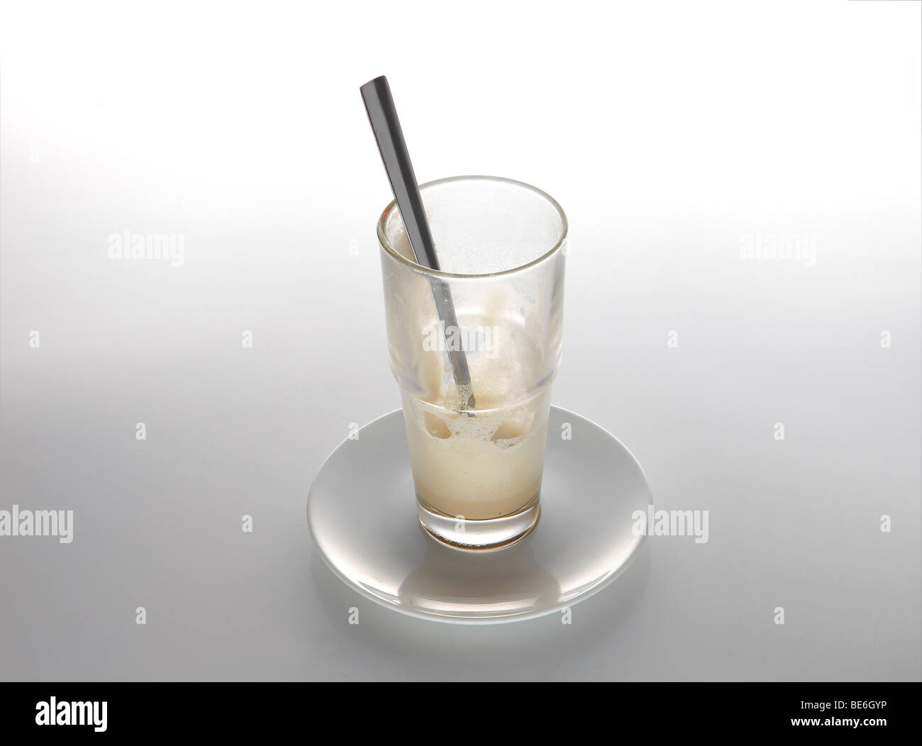 Bevuto il latte macchiato di vetro con cucchiaio Foto Stock