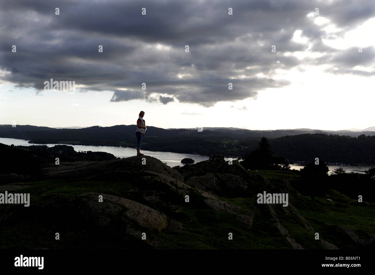 La donna sta al top della Brantfell sopra il Lago Windemere e la città di Bowness nel Lake District in Cumbria Regno Unito Foto Stock