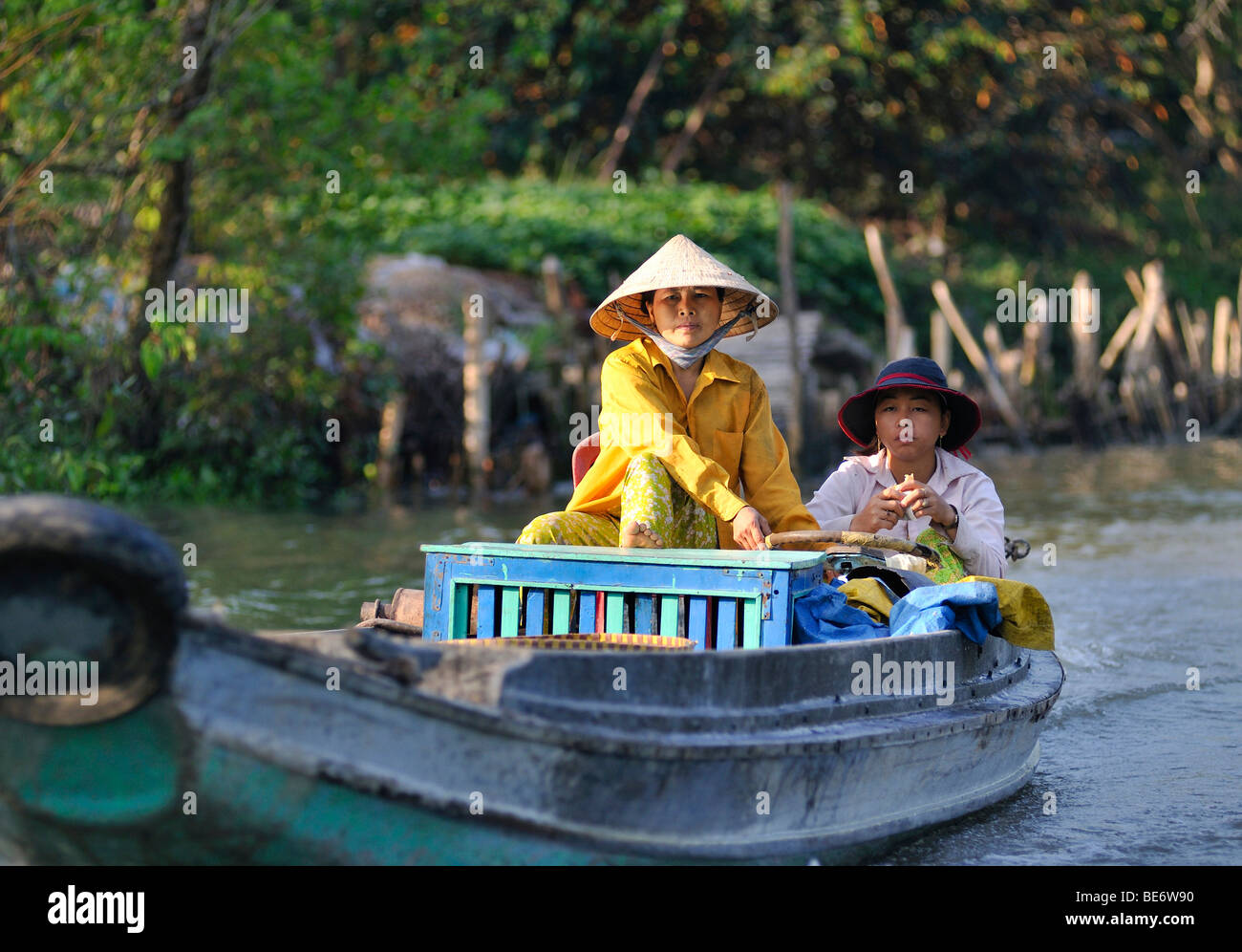 Due donne che indossano tradizionale vietnamita di cappelli di paglia in una barca sul fiume Mekong, Vinh Long, Delta del Mekong, Vietnam Asia Foto Stock