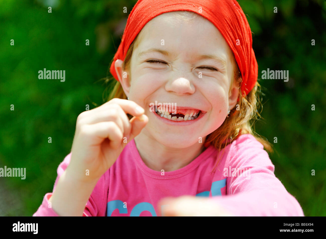 Bambina con un dente divario, top incisivi sono mancanti, felicemente sorridente al di sopra del dente perduto per il dente di fata Foto Stock