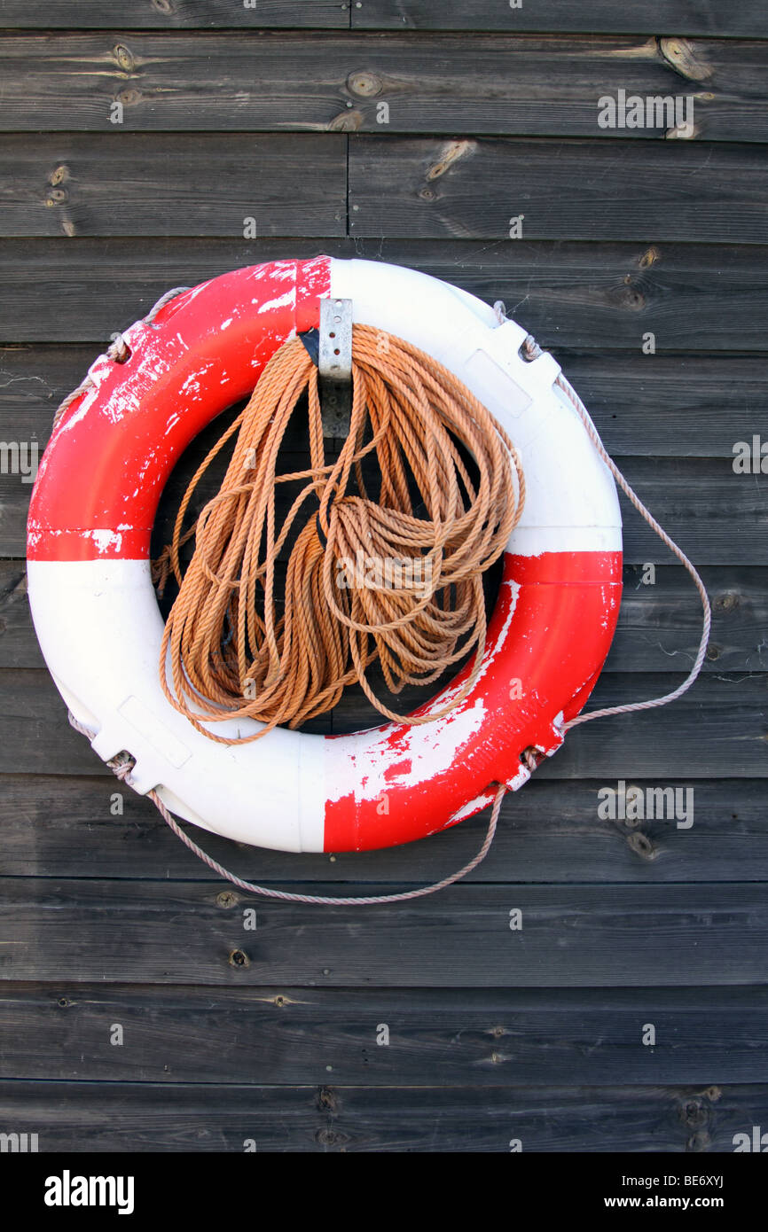 Salvagente fissata ad un vicino imbarcato parete in legno vicino a un pontile Foto Stock