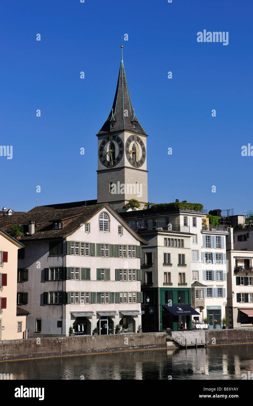 Torre della chiesa di San Pietro che si affaccia sui tetti del centro storico di Zurigo con la Limmat nel foregro Foto Stock
