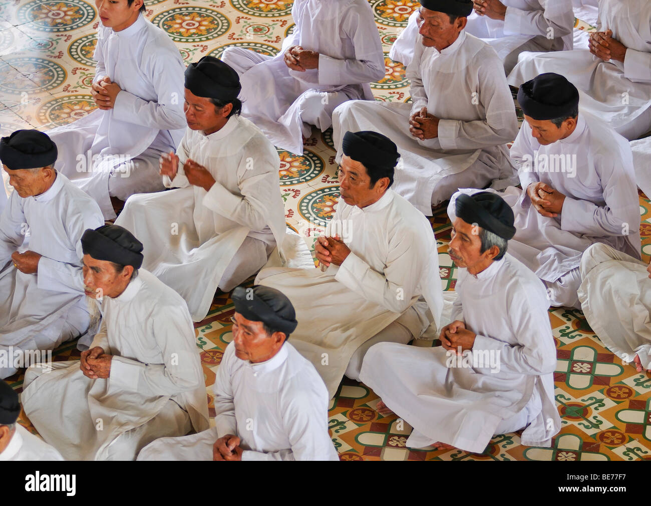 Pregando gli uomini pii, cerimoniale di preghiera di mezzogiorno in Cao Dai temple, Tay Ninh, Vietnam Asia Foto Stock