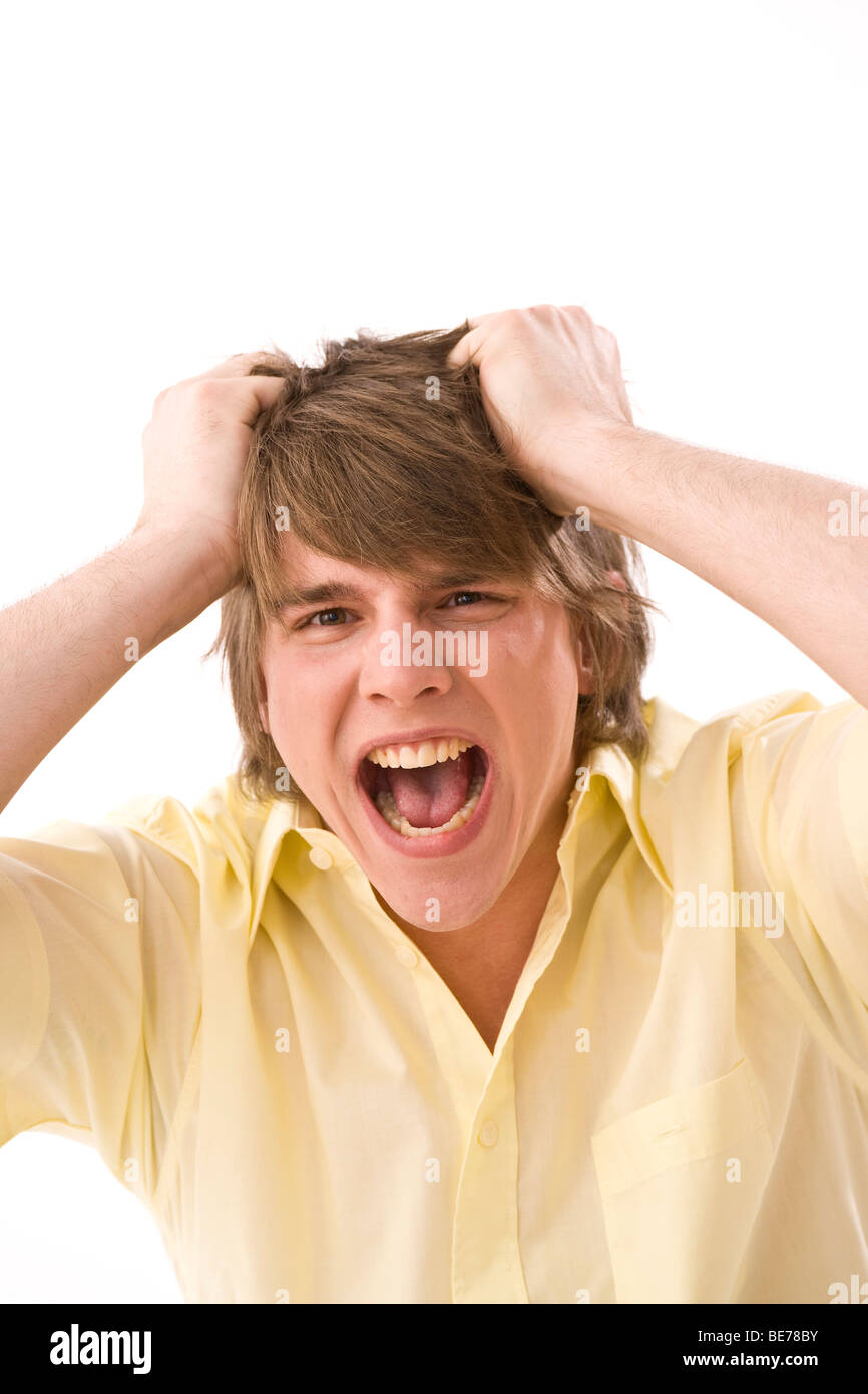 Giovane uomo a strappare i suoi capelli, urlando Foto Stock