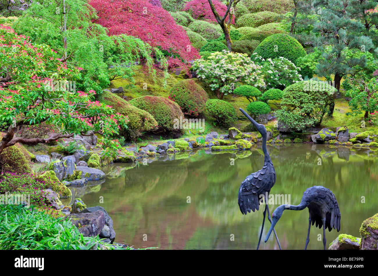 Stagno con heron scultura e inizio della primavera di crescita. Portland Giardini Giapponesi, Oregon. Foto Stock