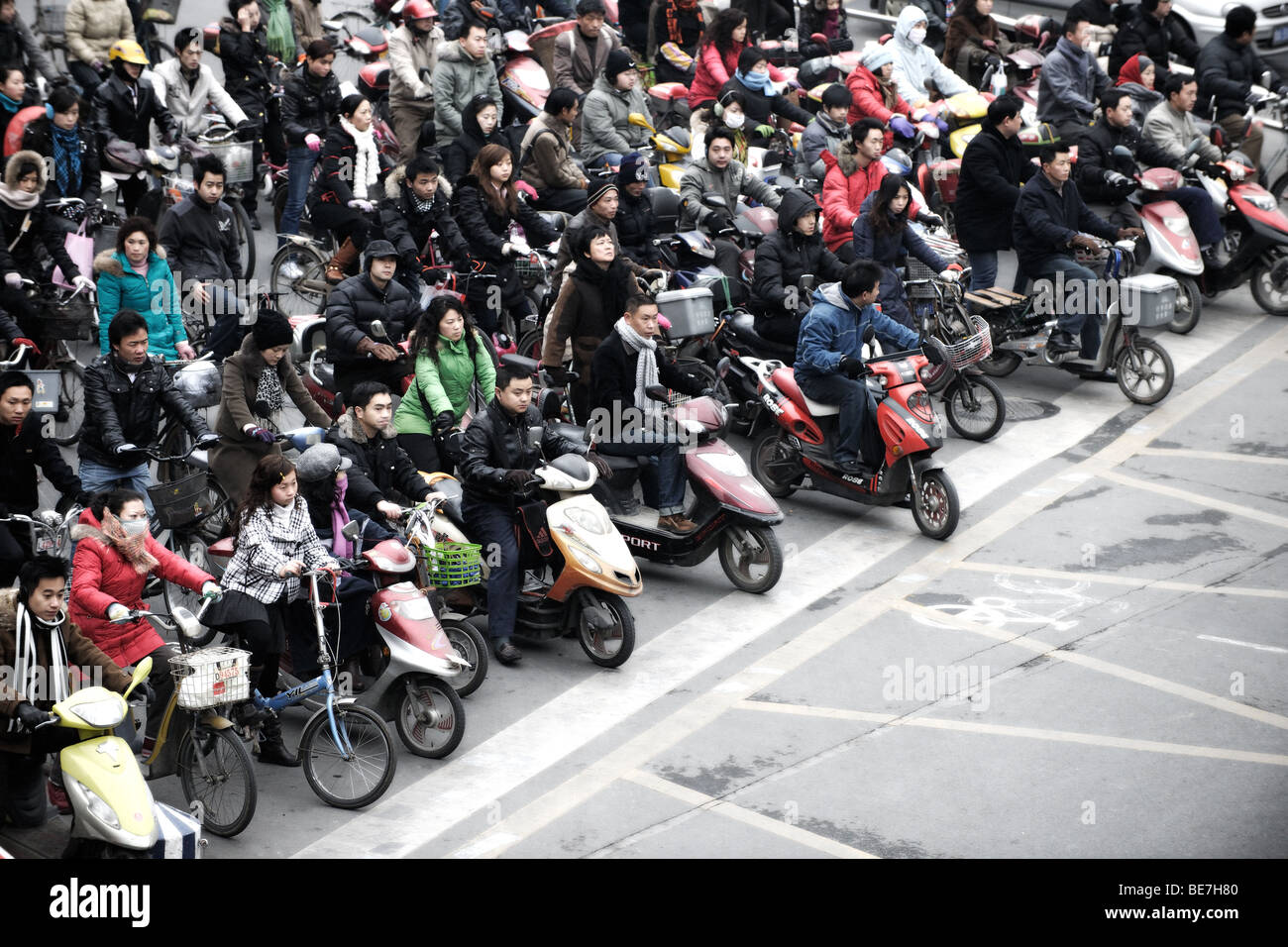 Folla sulle motociclette e biciclette di attraversare in Cina a Shanghai Foto Stock