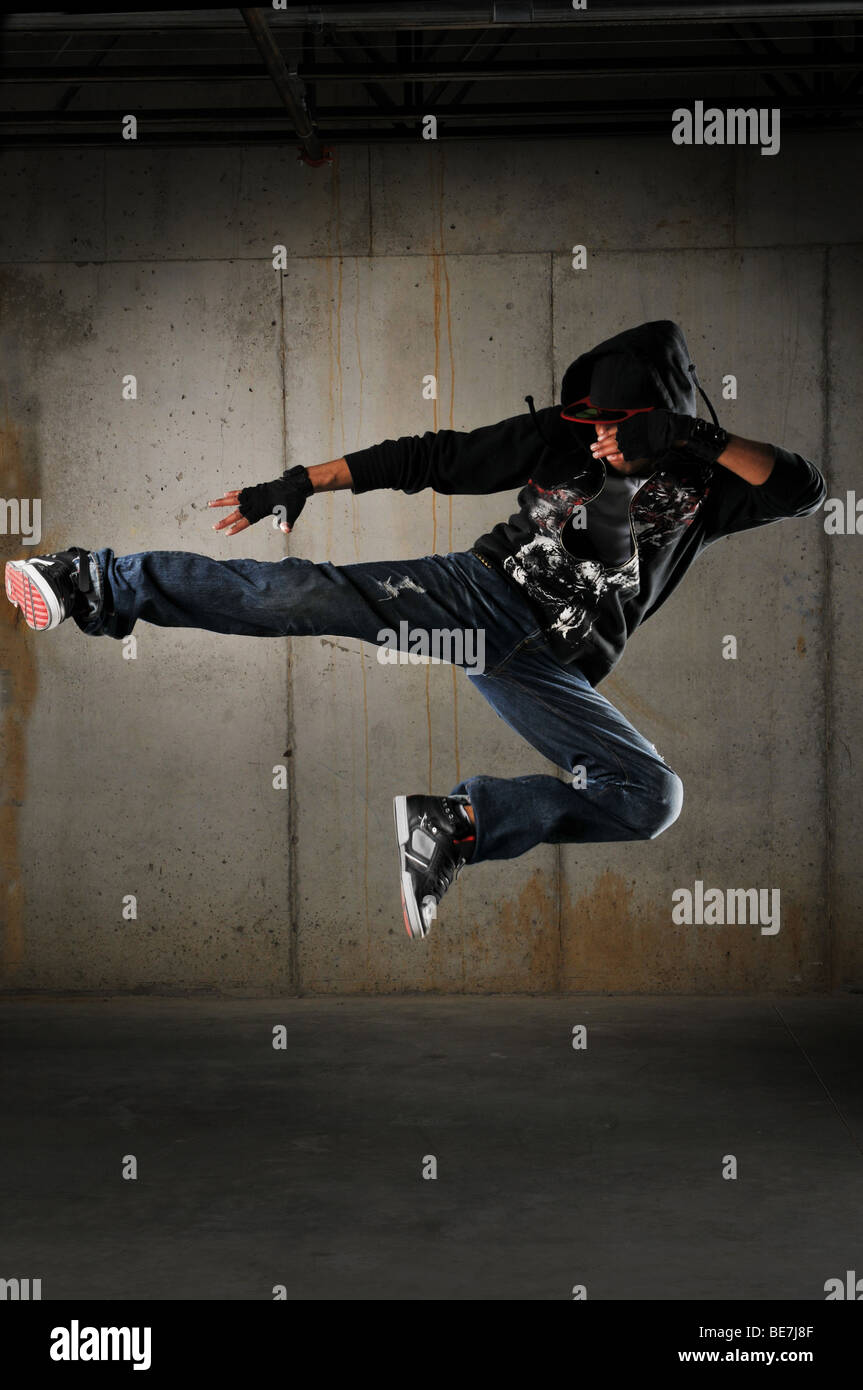 Hip hop dancer esecuzione contro una parete di grunge Foto Stock