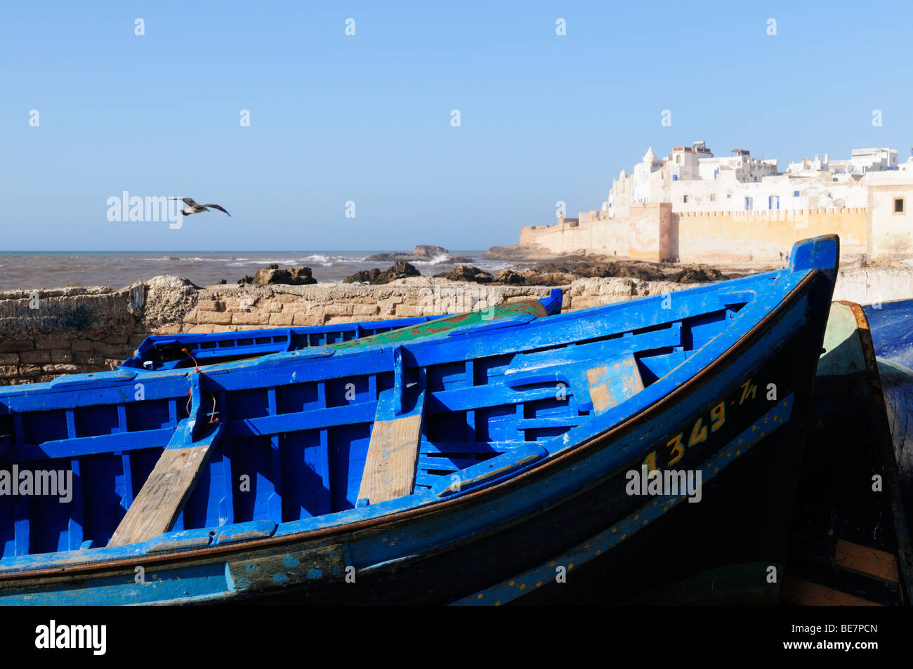 Barche blu, con vista dei bastioni e medina di Essaouira, Marocco Foto Stock