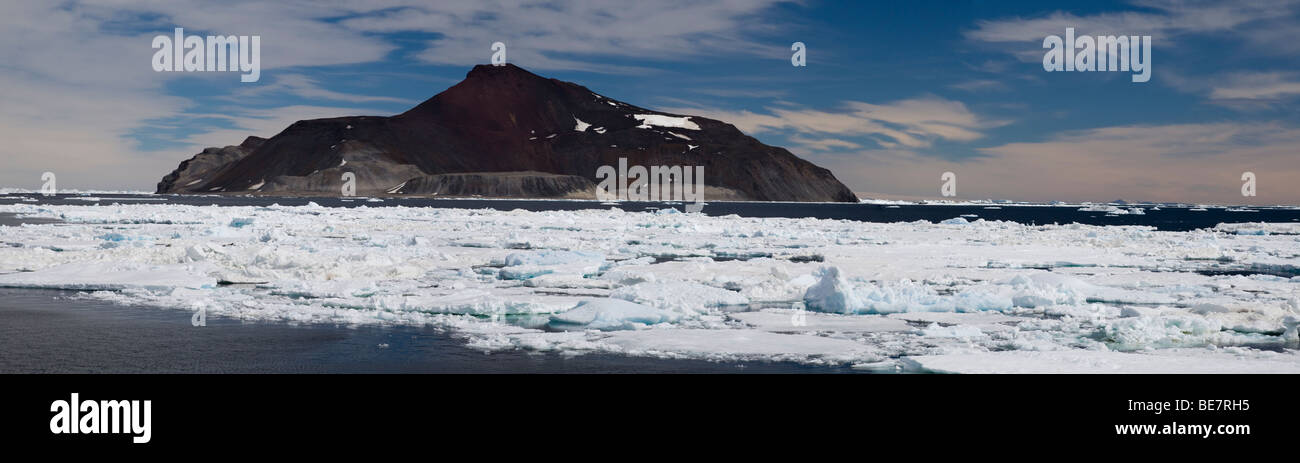 Vulcano remota isola Paulet Antartide circondato da glaçon alta montagna vulcanica, cielo azzurro sfondo con soffici nuvole bianche vista panoramica Foto Stock