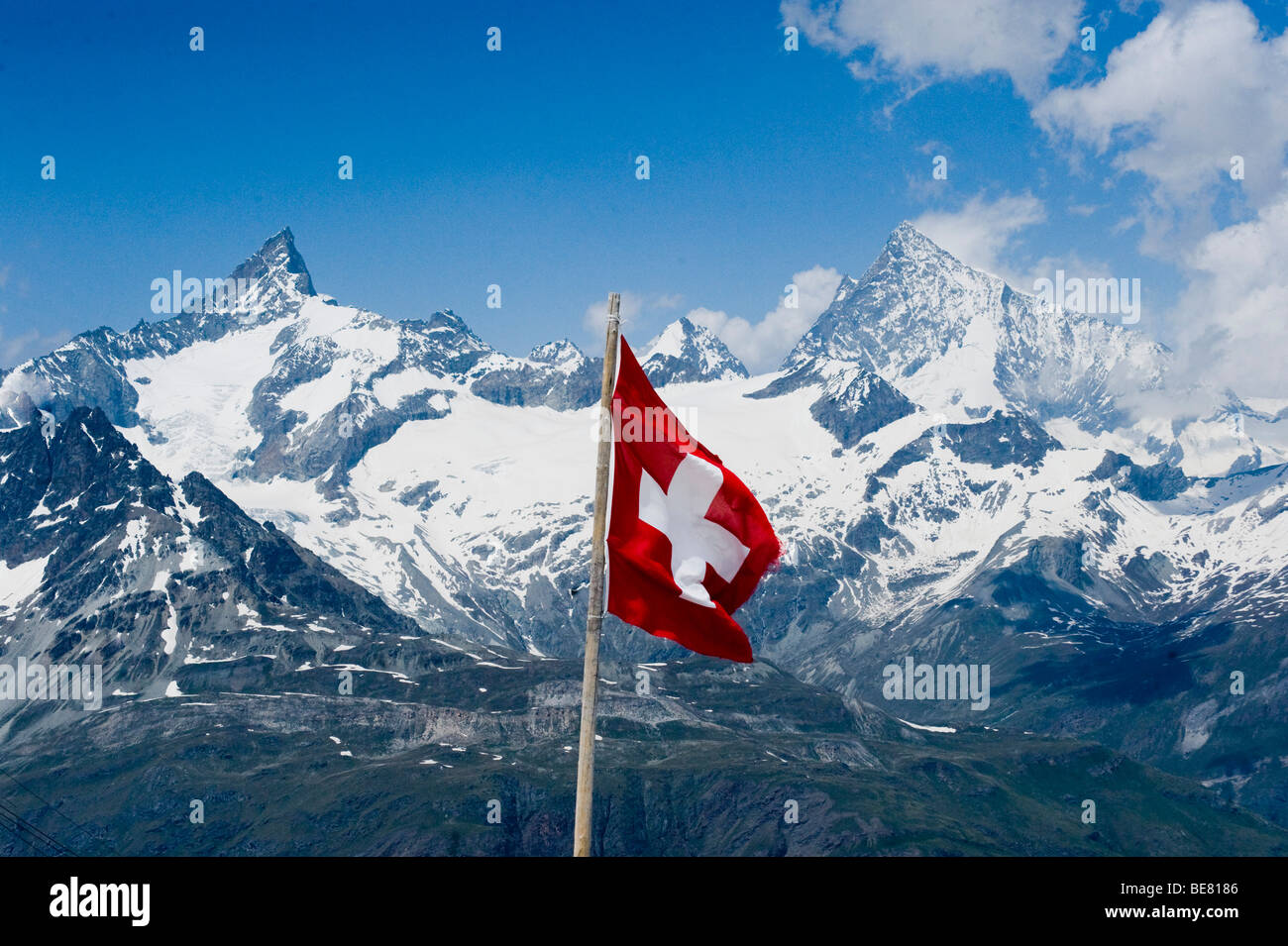 Bandiera svizzera in un paesaggio montuoso, Vallese, Svizzera Foto Stock