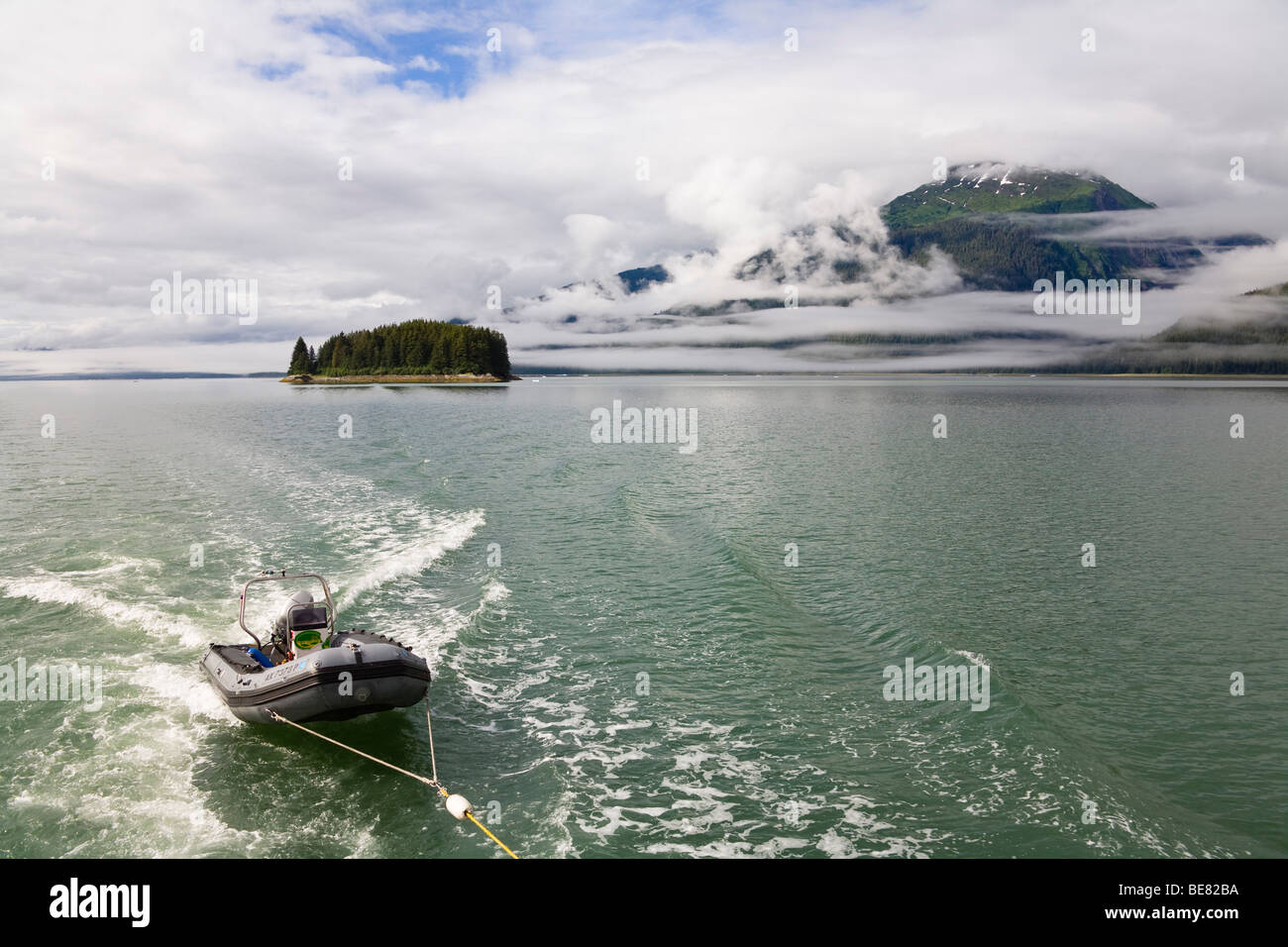 Persona in una barca nella parte anteriore del litorale sotto la copertura nuvolosa, Braccio Endicott, all'interno del passaggio, a sud-est di Alaska, STATI UNITI D'AMERICA Foto Stock