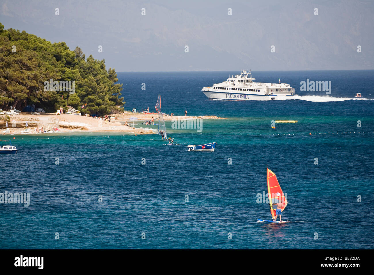 Una nave e surfer fuori dalla spiaggia presso il Golden Horn, Bol, Isola di Brac, Dalmazia, Croazia, Europa Foto Stock
