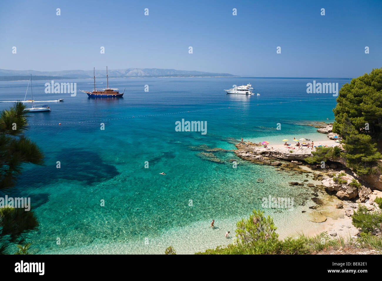 La spiaggia e le barche in una piccola baia, Isola di Brac, Dalmazia, Croazia, Europa Foto Stock